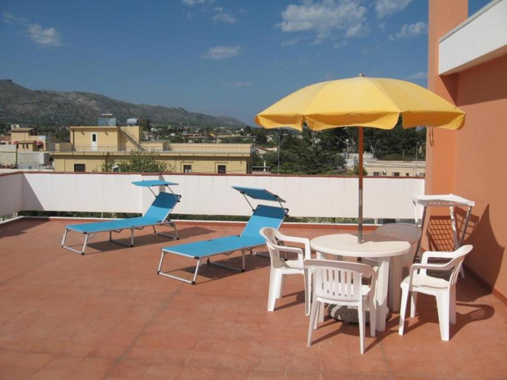 un patio con mesa, sillas y sombrilla en App Sebastiano en Avola