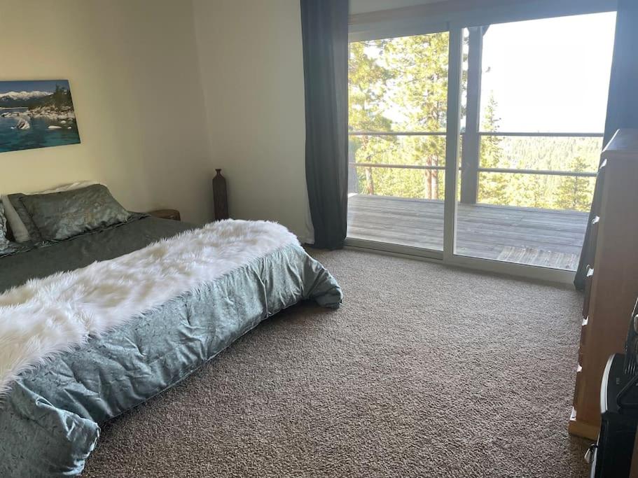 a bedroom with a bed and a sliding glass door at Tahoe Lake View Hill Top Retreat in Incline Village