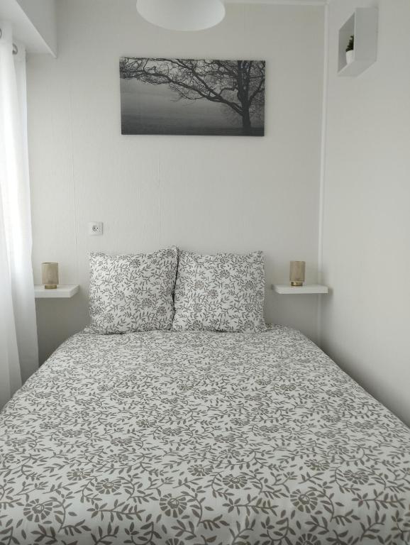 une chambre avec un lit avec une couette noire et blanche dans l'établissement Charmant T2 Dijon Congrexpo, à Dijon