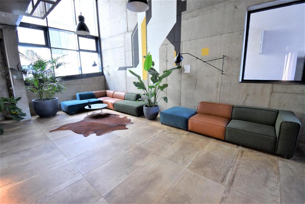 un salon avec des canapés et des plantes en pot dans l'établissement Jasminn Apartments, à Prague