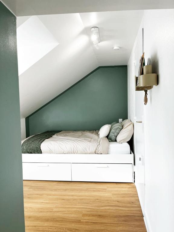 une chambre avec un lit dans une pièce blanche dans l'établissement HIDDEN NOOK NANTES - Studio plein centre Nantes, à Nantes