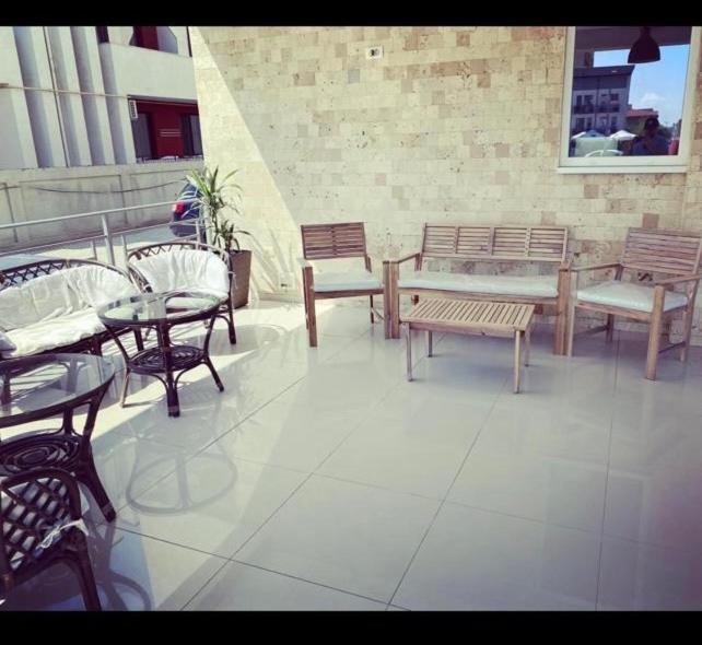 a patio with tables and chairs and a table and benches at Abi Mykonos in Mamaia Sat/Năvodari
