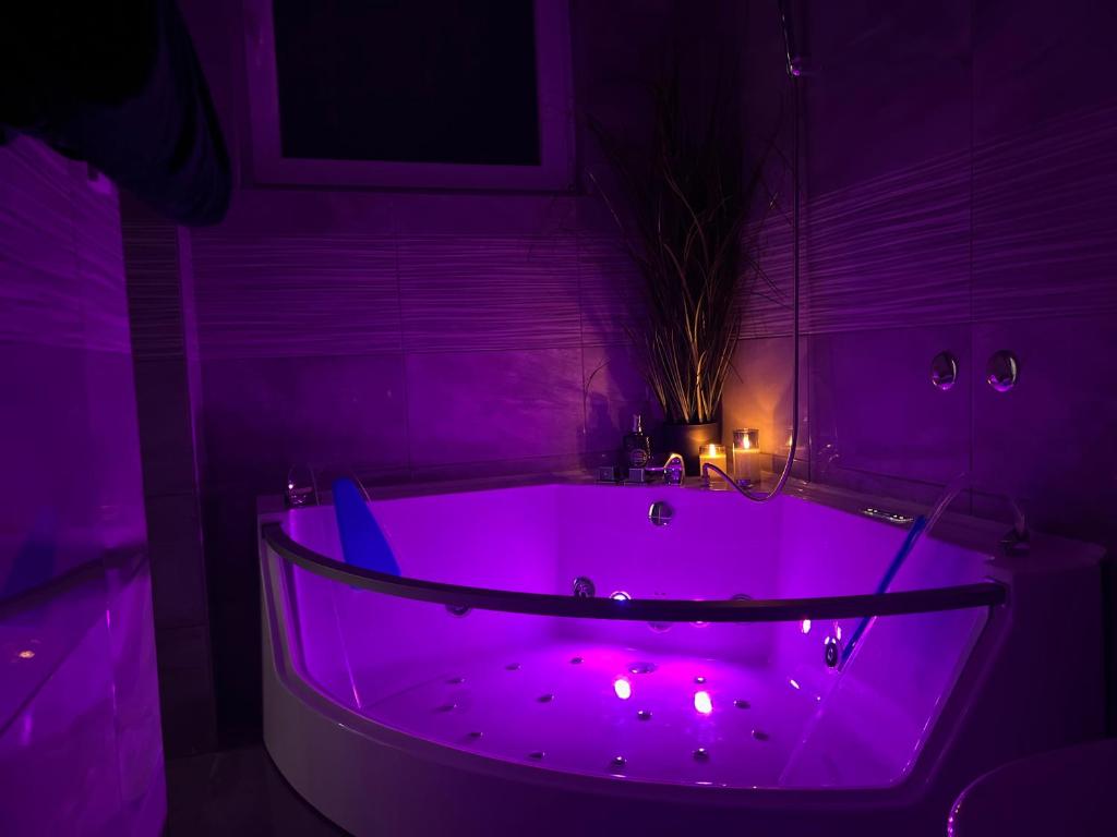 Baño púrpura con bañera con iluminación púrpura en LuxRooms BJELOVAR, en Bjelovar