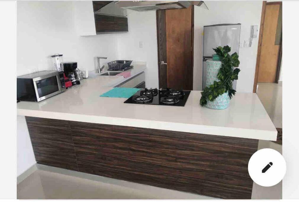 uma cozinha com um balcão com um fogão e um micro-ondas em Departamento en lomas de angelopolis, Isla blanca em Lomas de Angelopolis