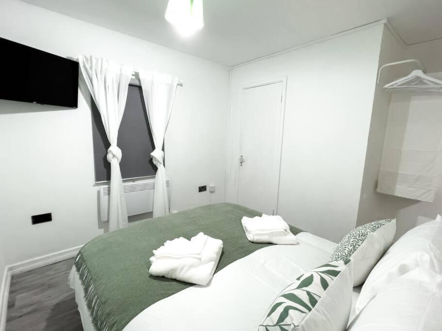 a bedroom with a bed with two pillows on it at Studio with Bathroom and Kitchen 20 minutes from Central London in London