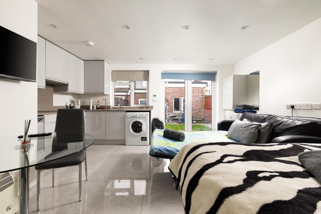 a kitchen and a living room with a bed and a table at Garden Studio flat in Hendon in Hendon