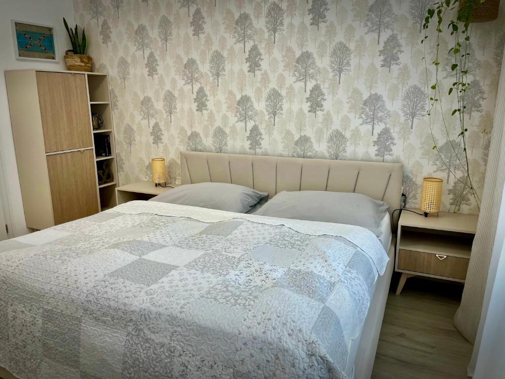 a bedroom with a bed and two tables and a wall at Danube12 in Šamorín