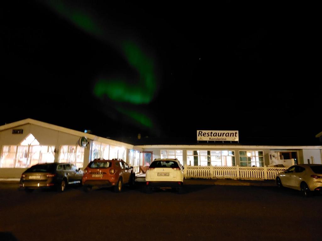 a group of cars parked in a parking lot in front of a restaurant at Hotel Kanslarinn Hella in Hella