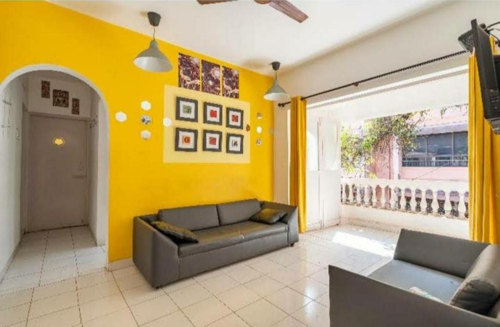 卡蘭古特的住宿－Luxury 3 bhk beach apartment Calangute，带沙发和黄色墙壁的客厅