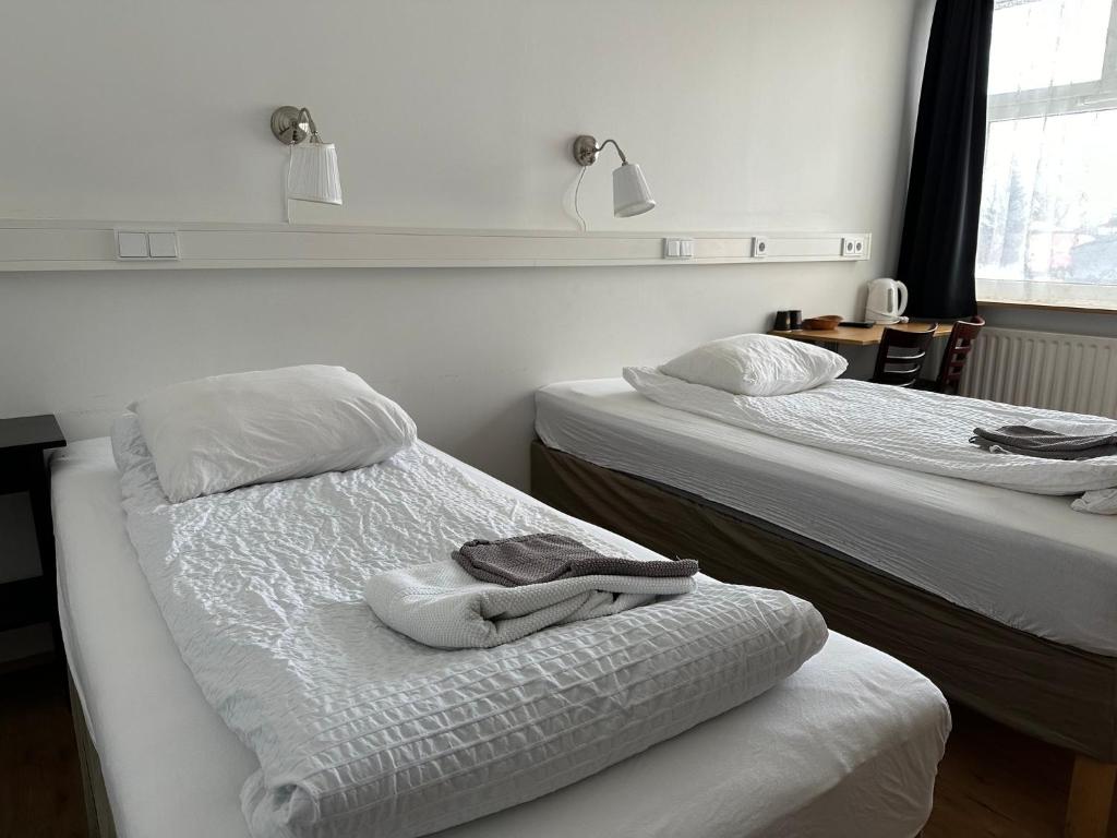 Habitación con 2 camas y toallas. en Kanslarinn Hostel en Hella