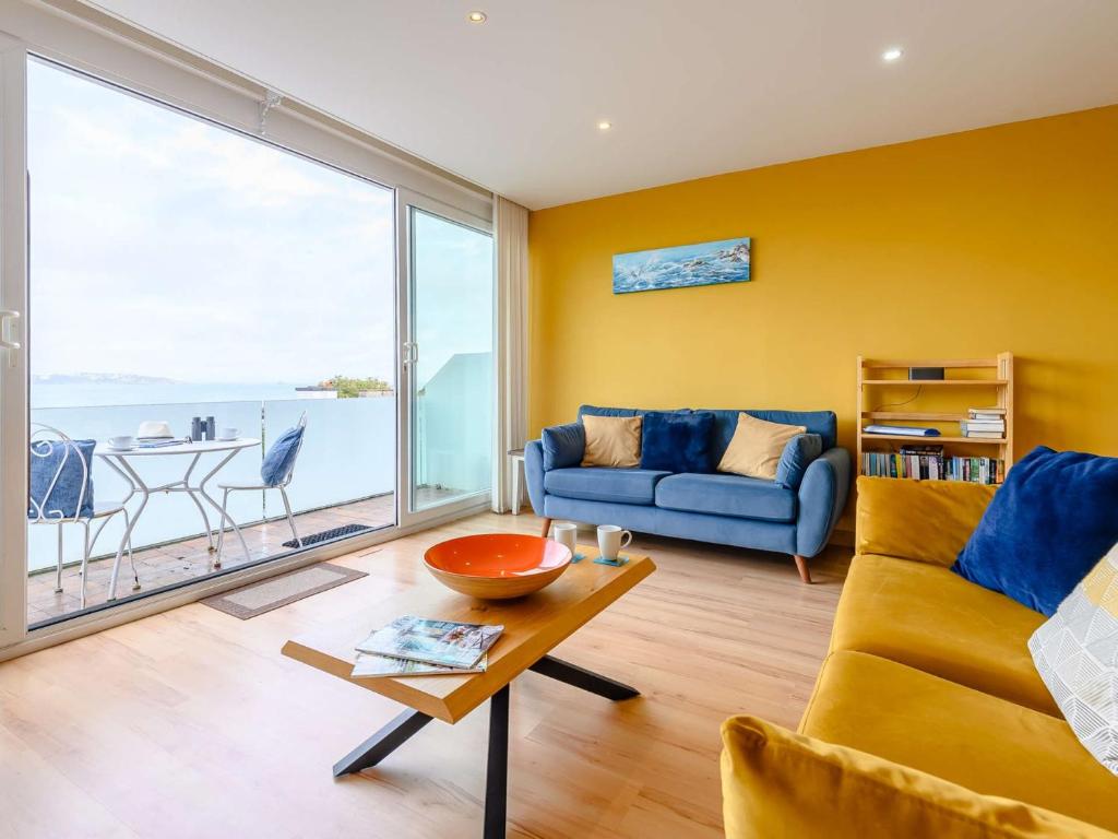a living room with a blue couch and a large window at 3 Bed in Brixham BX004 in Brixham