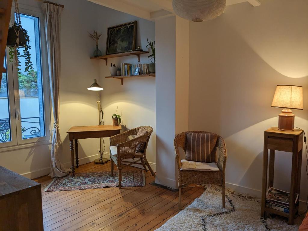 ein Wohnzimmer mit einem Tisch und 2 Stühlen in der Unterkunft Chambre bohème au calme in Montrouge