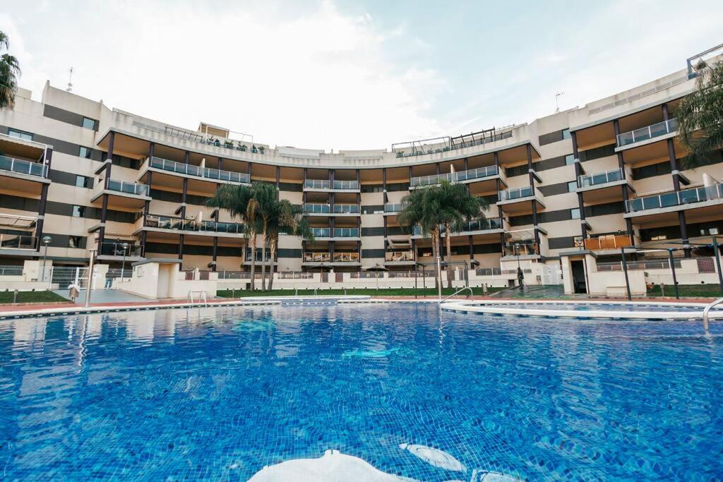 una gran piscina frente a un edificio en Lujoso apartamento de dos habitaciones en la playa de Canet en Canet de Berenguer