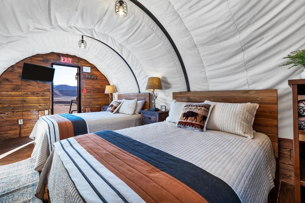 um quarto com 2 camas numa tenda em Zion White Bison Glamping & RV Resort em Virgin