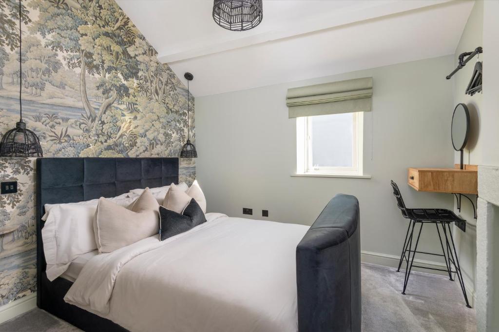 - une chambre avec un grand lit et une fresque murale dans l'établissement Gibson Cottage, à Penrith