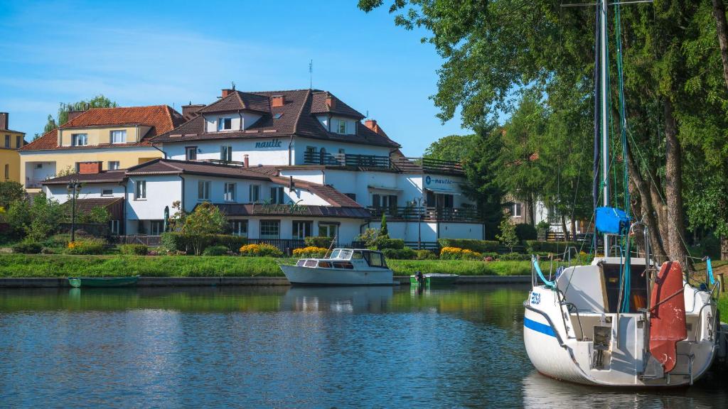 two boats in the water in front of a house at B&B NAUTIC - Jezioro Mamry, Green Velo in Węgorzewo