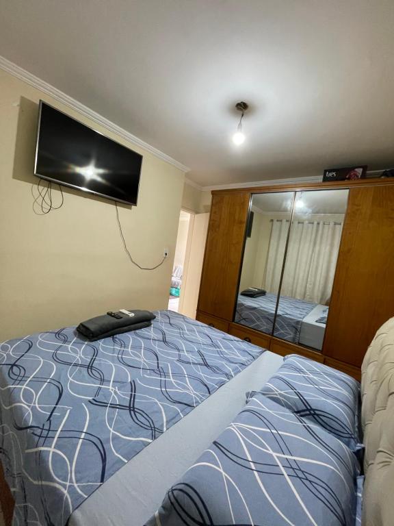 een slaapkamer met een bed en een flatscreen-tv bij Confortável e aconchegante! in Aracaju