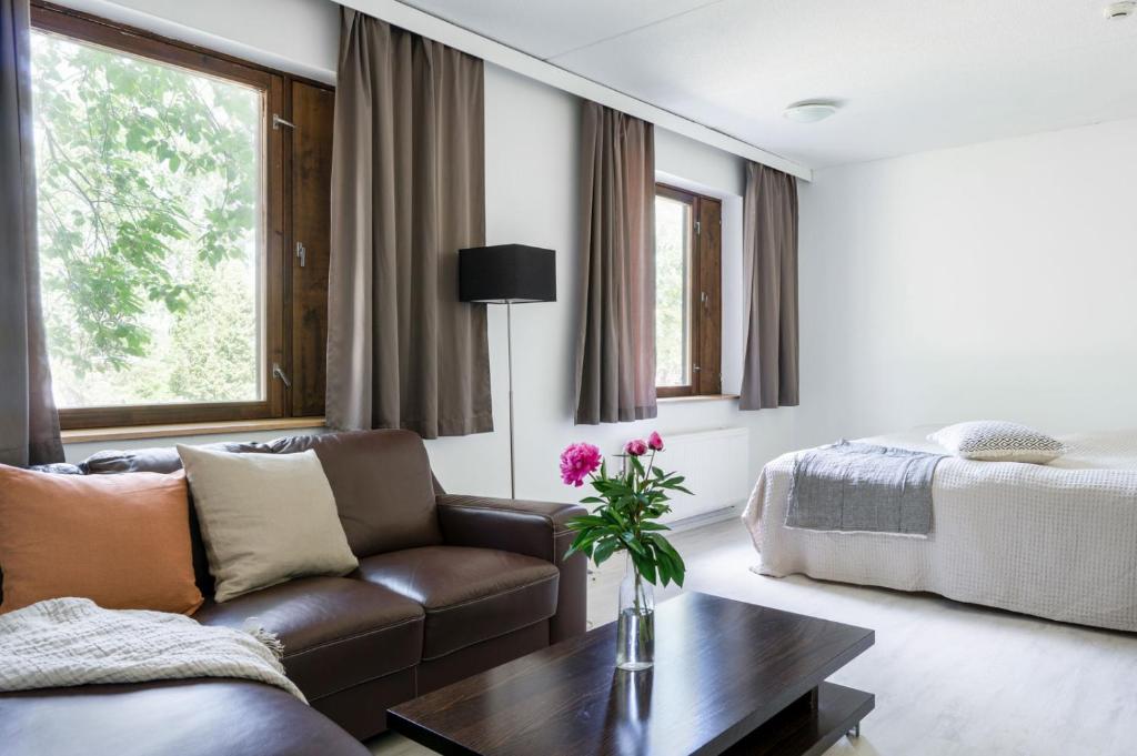 een woonkamer met een bank en een bed bij Air Hotel Nummela in Nummela