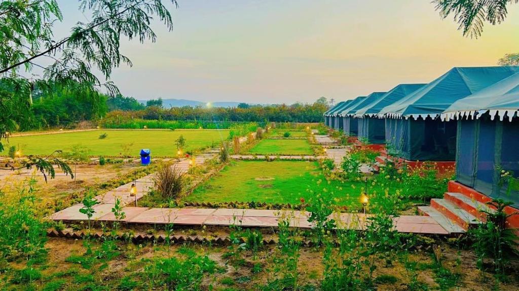 a garden with a building and a field of plants at Pritampalace resort in Khilchipur