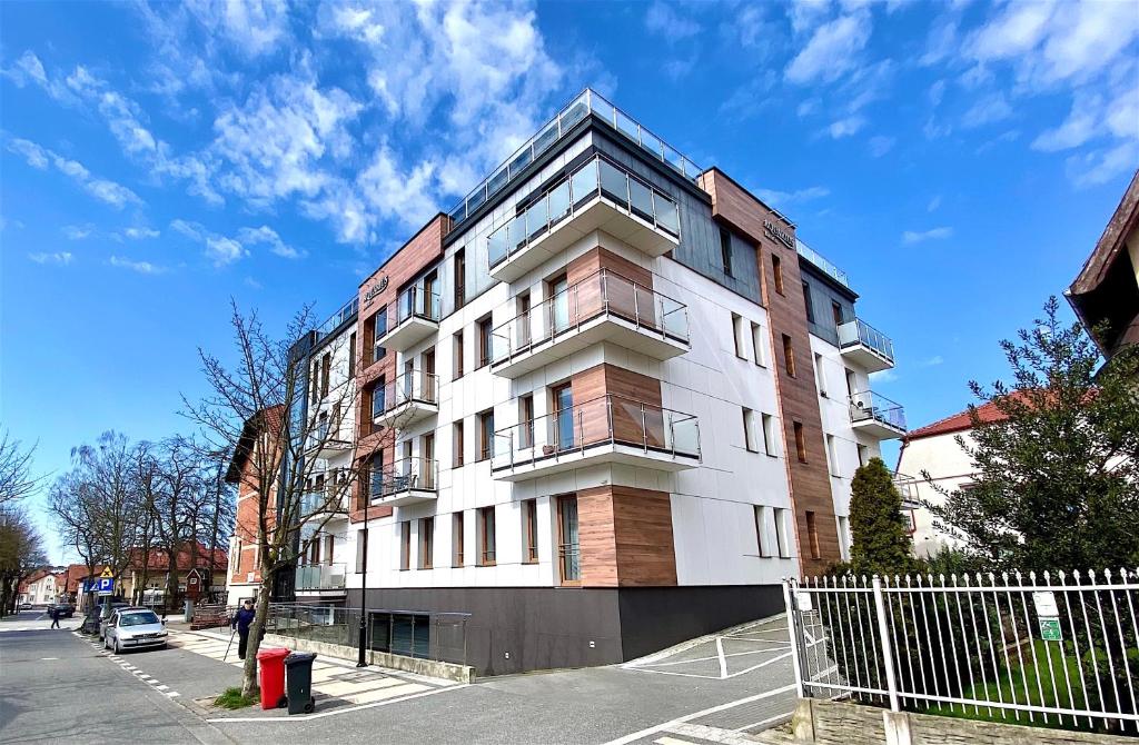 Un alto edificio bianco sul lato di una strada di Apartamenty Marea Rentals Aquarius Ustka a Ustka