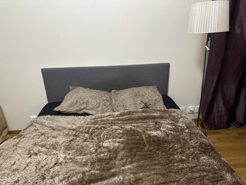 een bed met een deken en kussens erop bij Nol in Göteborg