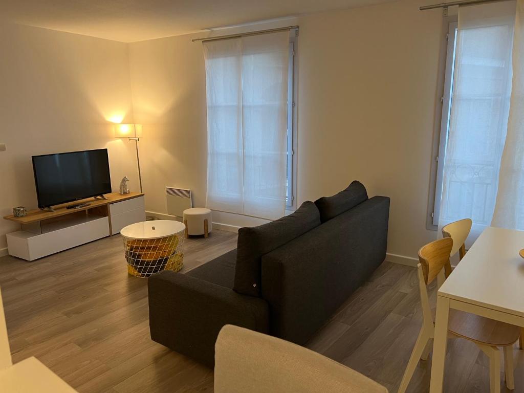 un salon avec un canapé et une télévision dans l'établissement Le Quarante Deux, à Serris