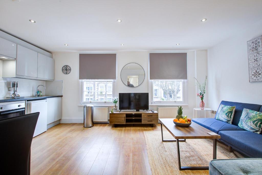 a living room with a blue couch and a table at Gorgeous 1 Bedroom Property in London