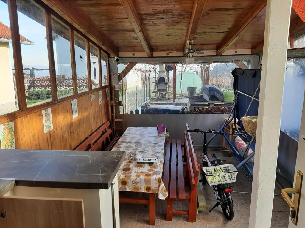 uma cozinha com uma mesa e uma bicicleta num quarto em Erdei fenyö vendeghaz em Lenti