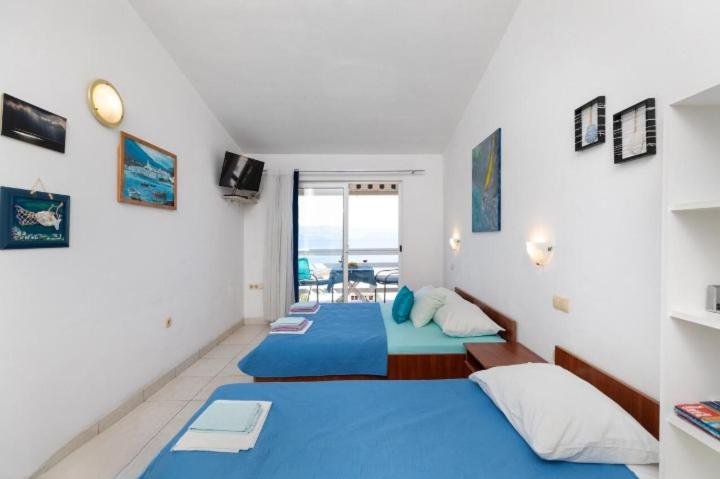 a bedroom with two beds and a view of the ocean at Apartments Boris in Omiš