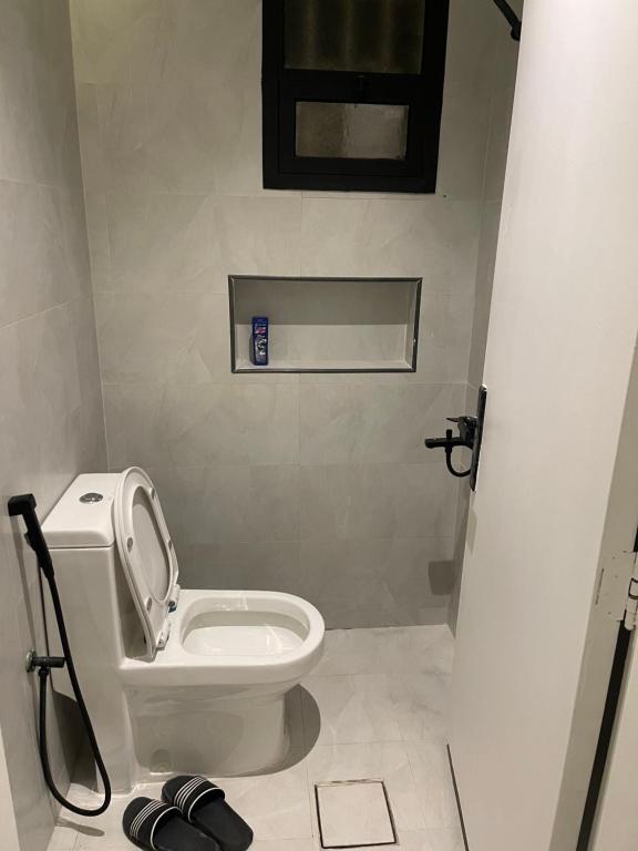 a bathroom with a white toilet in a room at غرفة وصالة دخول ذكي العقيق in Riyadh