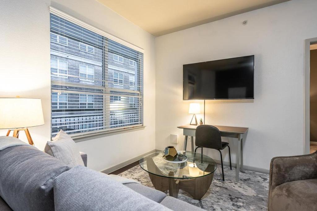 a living room with a couch and a table and a television at Landing - Modern Apartment with Amazing Amenities (ID5045X8) in San Antonio