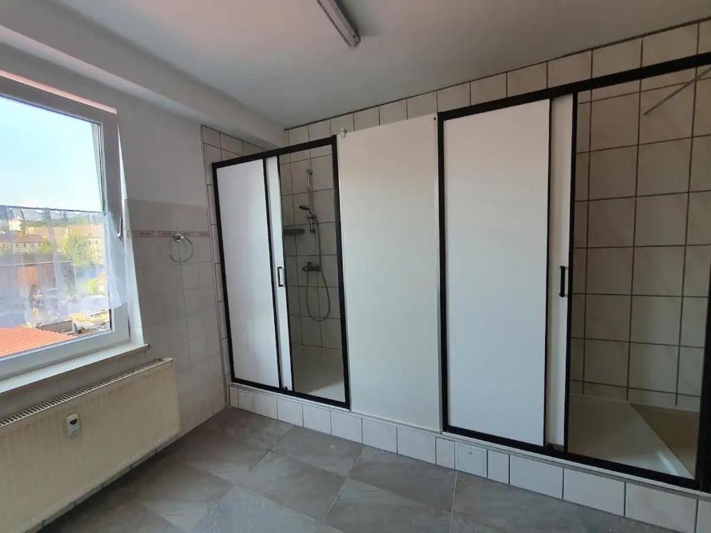a bathroom with three windows and a shower at Schöne Wohnung in Eisenach in Eisenach