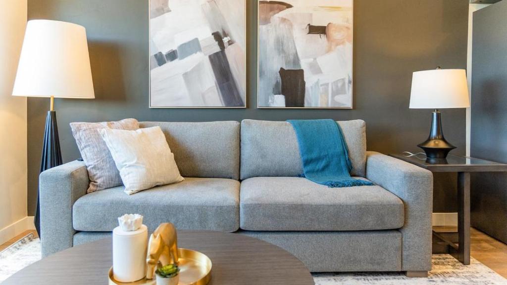 ein Wohnzimmer mit einem blauen Sofa und 2 Lampen in der Unterkunft Landing - Modern Apartment with Amazing Amenities (ID2399X88) in Salt Lake City