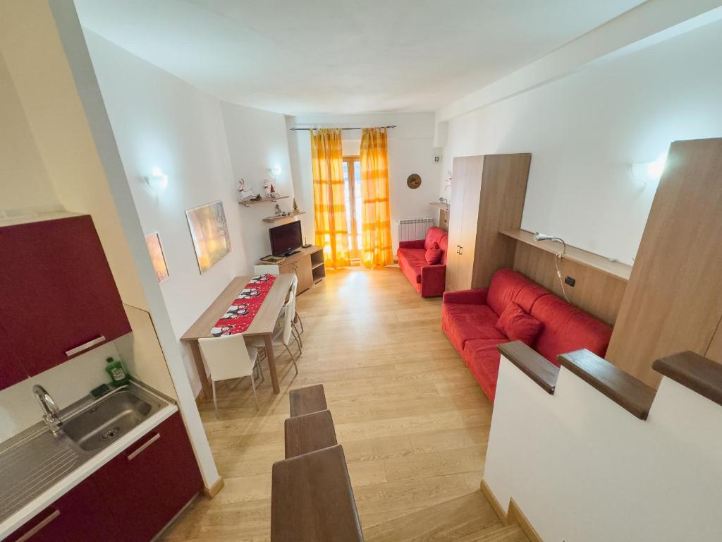 een woonkamer met een rode bank en een tafel bij Monolocale sulle piste da sci in Pila