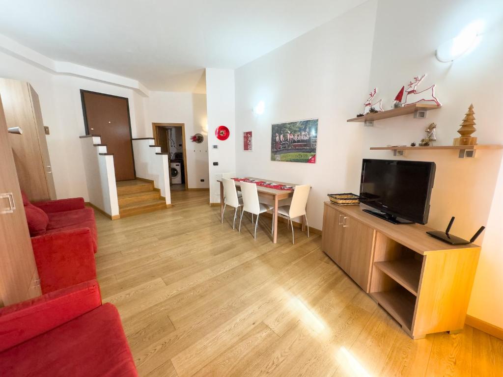 a living room with a red couch and a television at Monolocale sulle piste da sci in Pila