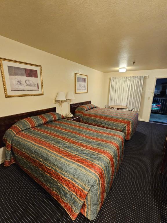 a hotel room with two beds and a window at Terrace Inn and Suites in El Cerrito
