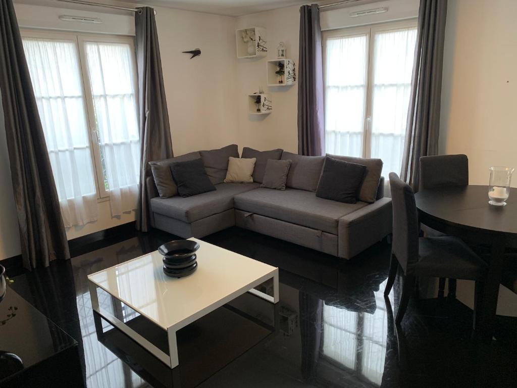 un salon avec un canapé et une table dans l'établissement Thao, à Serris