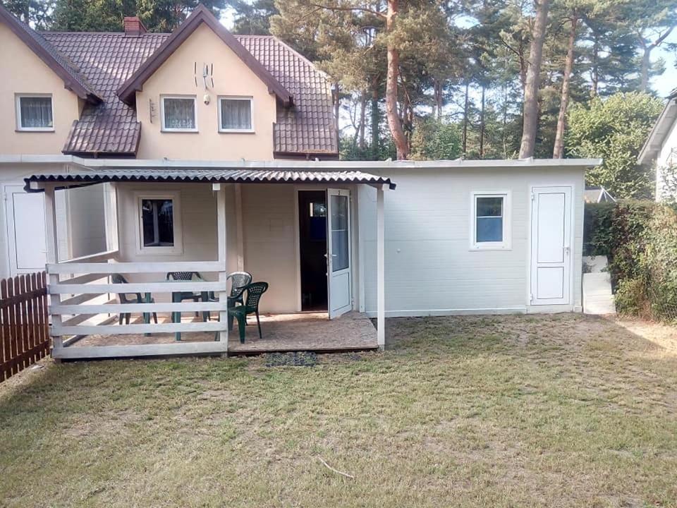 une maison individuelle avec une terrasse couverte et une clôture dans l'établissement Domek 2, à Dębki