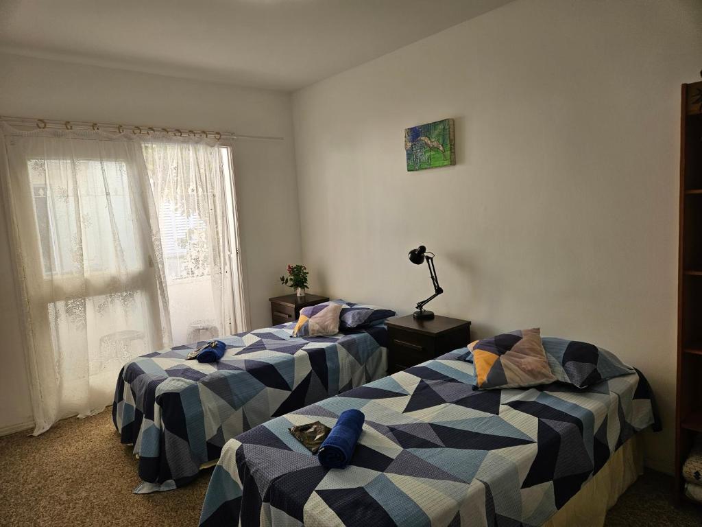 a room with two beds and a window at Espaço Semente Poa Lírio in Porto Alegre