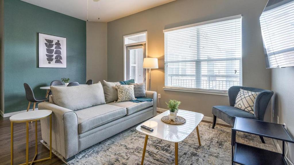 uma sala de estar com um sofá e uma mesa em Landing - Modern Apartment with Amazing Amenities (ID5045X9) em San Antonio