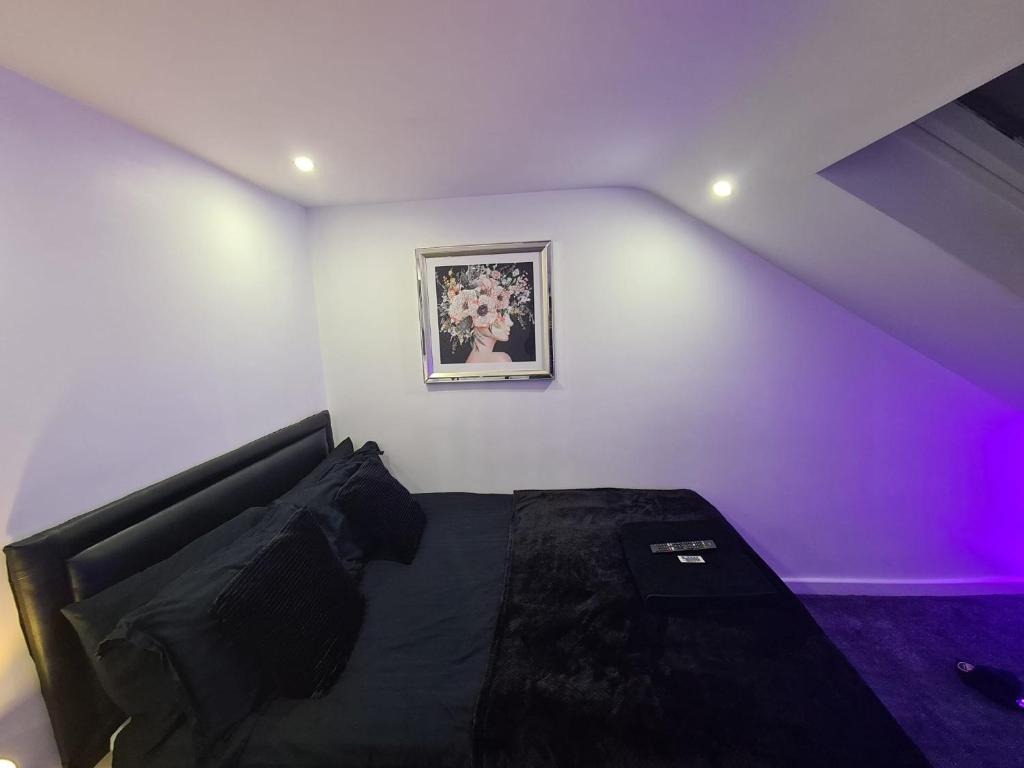 um quarto com uma cama e um quadro na parede em Hornet's Hideout em Watford