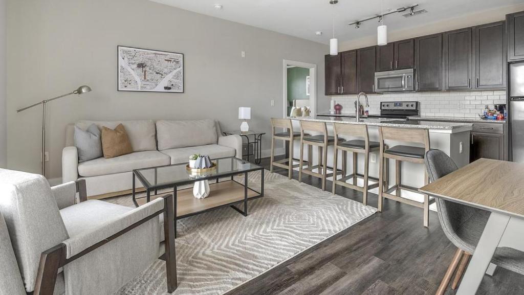 een woonkamer met een bank en een keuken bij Landing - Modern Apartment with Amazing Amenities (ID1284X157) in Charlotte