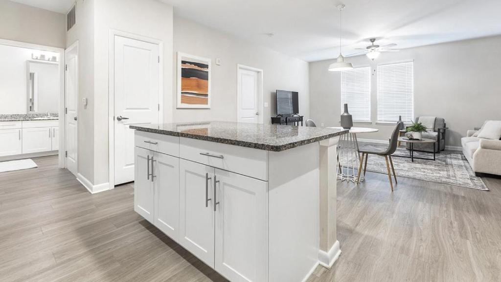een keuken en een woonkamer met witte kasten en een tafel bij Landing - Modern Apartment with Amazing Amenities (ID2966X03) in Charleston