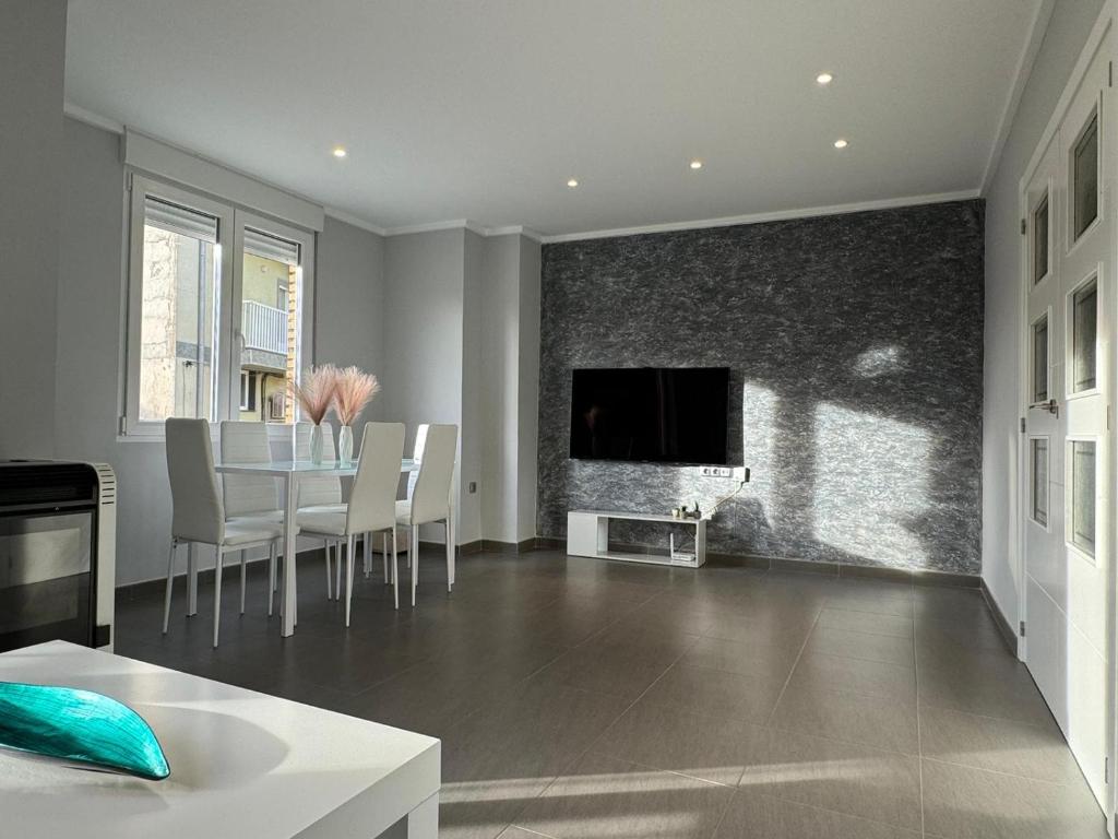 Apartamento Novo en Montealegre amplio y comodo في Montealegre del Castillo: غرفة معيشة مع طاولة وتلفزيون على الحائط