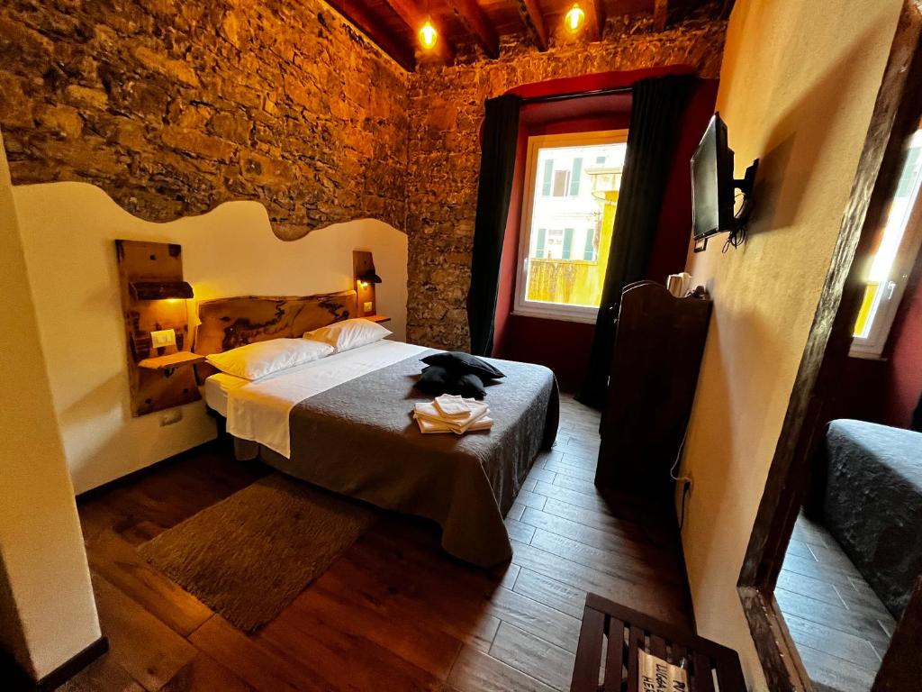 een slaapkamer met een bed met een kat erop bij La Taverna del Metallo Rooms in La Spezia