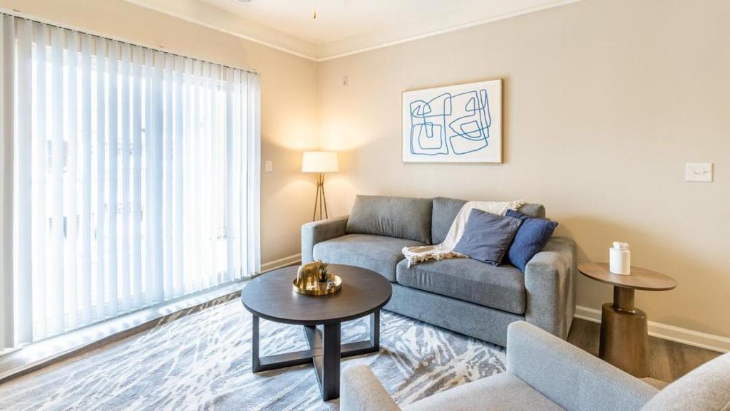 uma sala de estar com um sofá e uma mesa em Landing - Modern Apartment with Amazing Amenities (ID8445X18) em Wake Forest