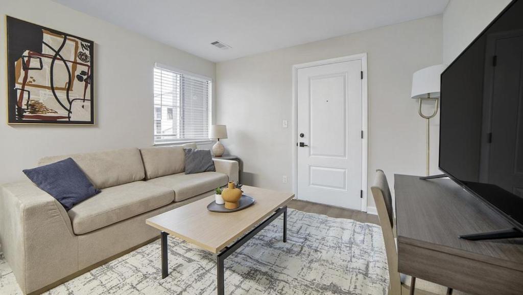 een woonkamer met een bank en een tafel bij Landing - Modern Apartment with Amazing Amenities (ID1292X514) in Lexington
