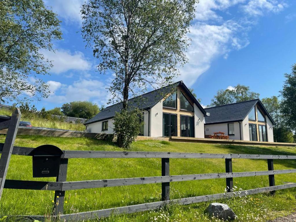 uma casa branca com uma cerca à frente. em Camden House luxury home near Ben Nevis Scotland Highlands em Fort William