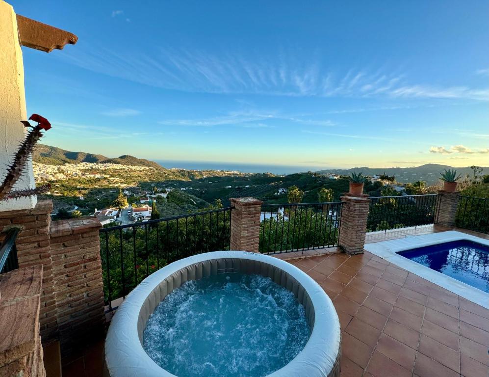 a hot tub on the balcony of a house at Villa en Frigiliana con piscina, jacuzzi y espectaculares vistas in Frigiliana