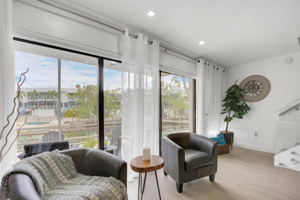 a living room with a couch and chairs and a large window at Overlooking Saltwater Lagoon Free Golf Cart-Kayaks in Key Largo